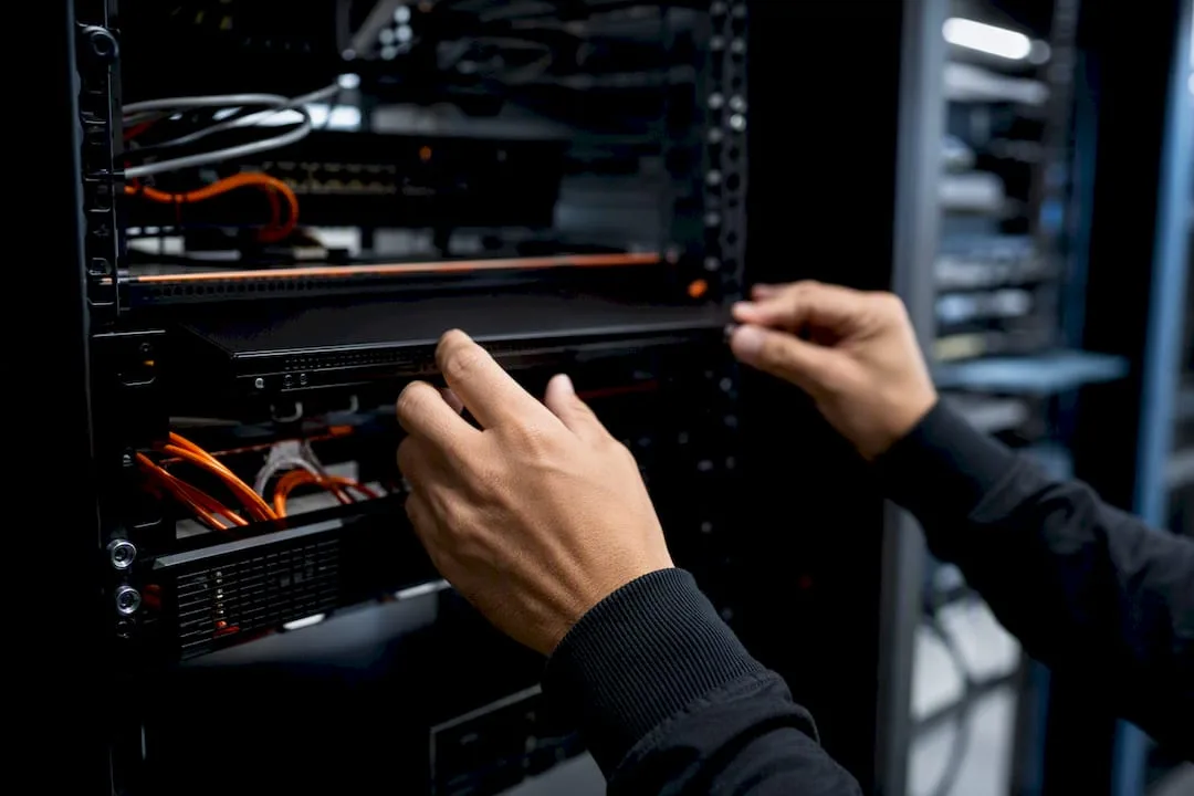 Hands adjusting network node hardware in rack